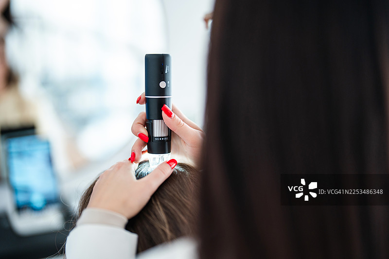 美容水疗中心专家使用先进工具检查头皮图片素材