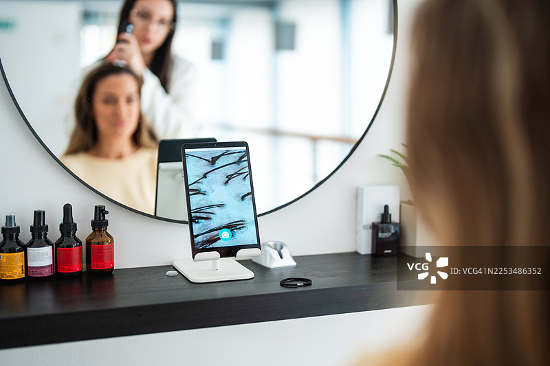 白种女性在接受水疗专家进行的头发检查图片素材