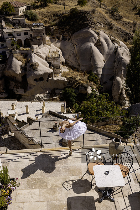 身着白色芭蕾舞裙的芭蕾舞者在石阶上表演图片素材