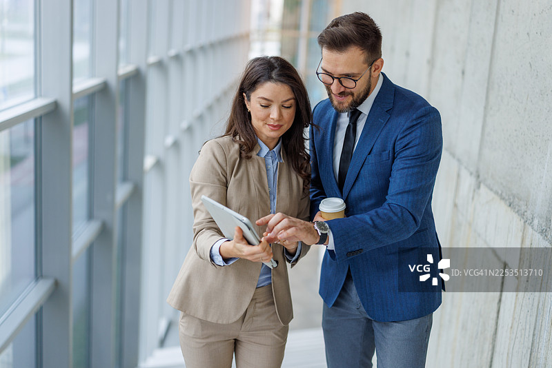 商务同事在现代办公室里协作使用数字平板电脑图片素材