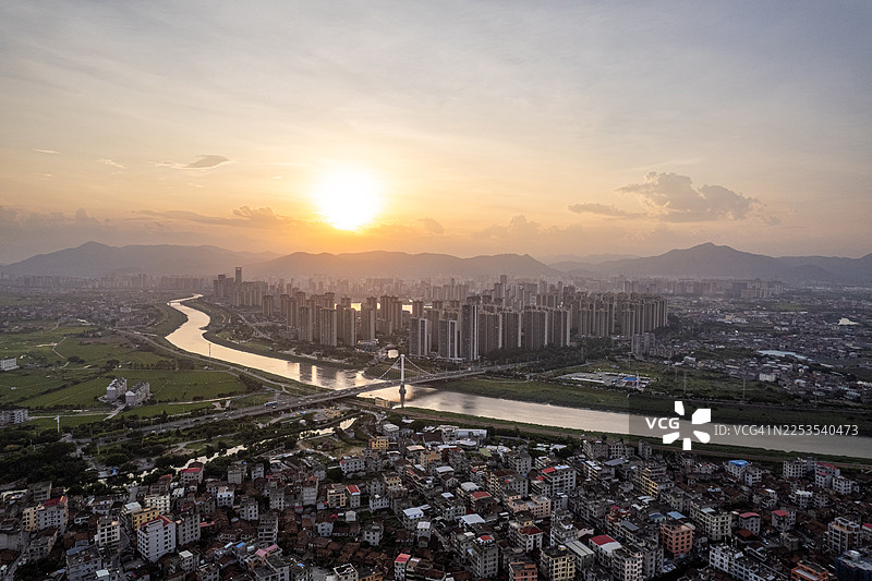 黄昏时分，一座横跨河流的桥梁与城市摩天大楼。图片素材