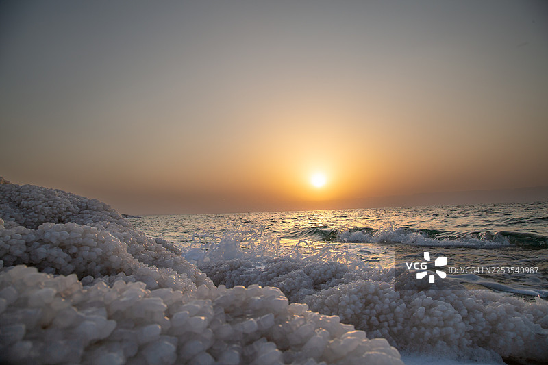 约旦死海日落时分，海天一色的美景，岸边有盐晶地貌图片素材