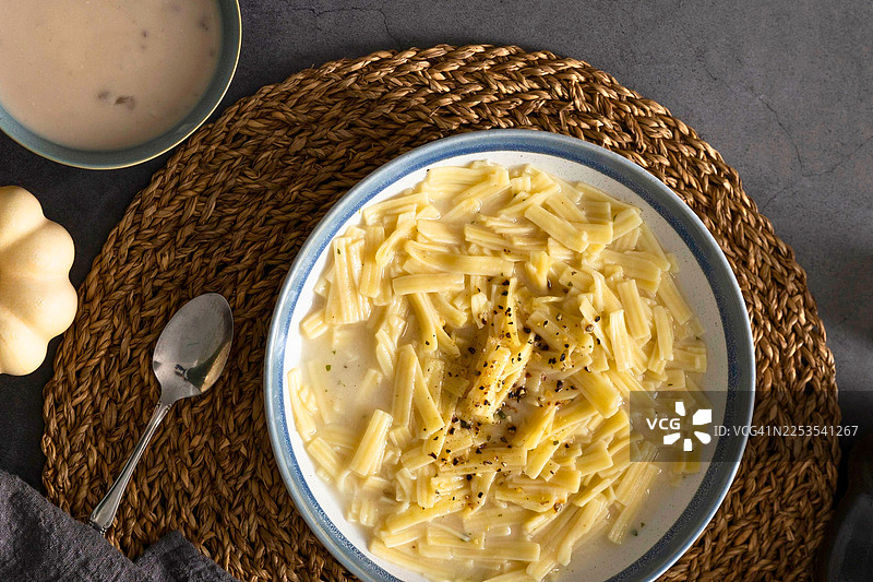 从正上方拍摄的碗装意大利面，旁边配有汤，放在桌子上图片素材