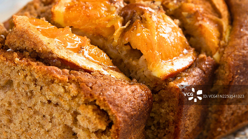 特写镜头，展示了刚出炉的涂有水果糖釉的烤面包的质感和温暖的色泽图片素材