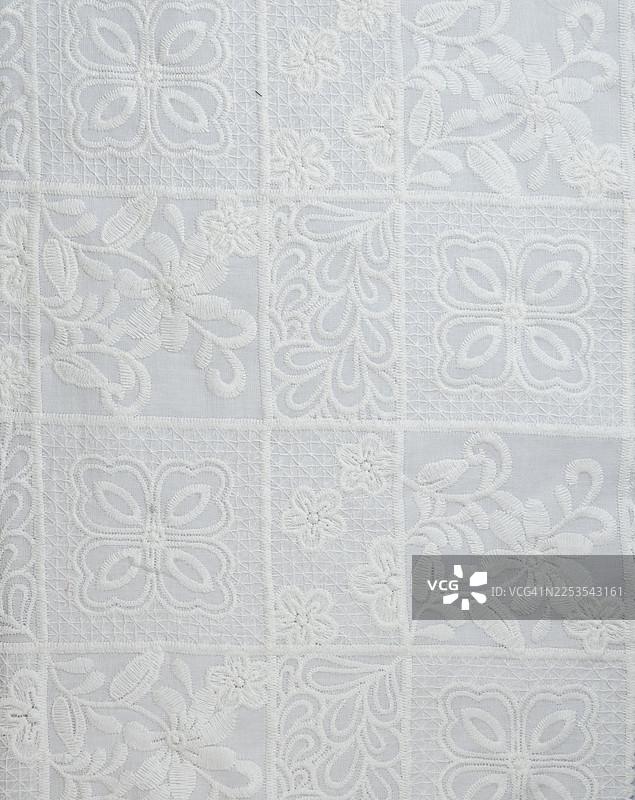 全景镜头拍摄的白色刺绣蕾丝面料图片素材
