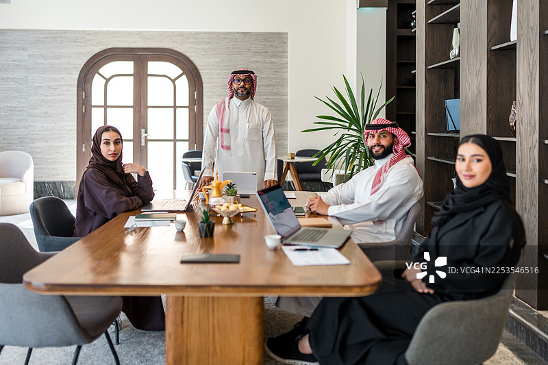自信的阿拉伯商务专业人士在现代办公室协作图片素材