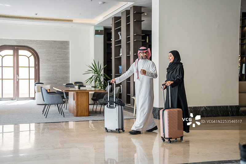 迷人的阿拉伯情侣兴高采烈地步入酒店大堂图片素材