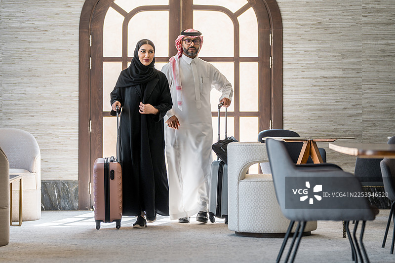 快乐的阿拉伯夫妇抵达豪华酒店图片素材