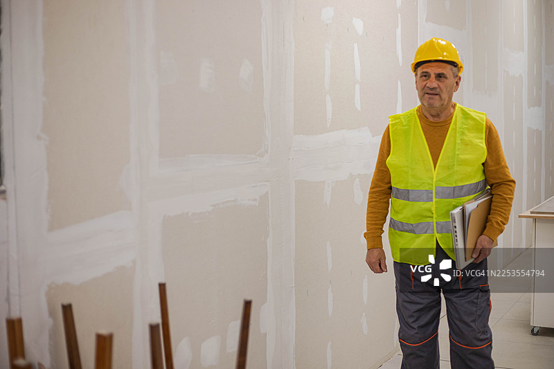 经验丰富的建筑工人正在使用笔记本电脑检查建筑工地图片素材