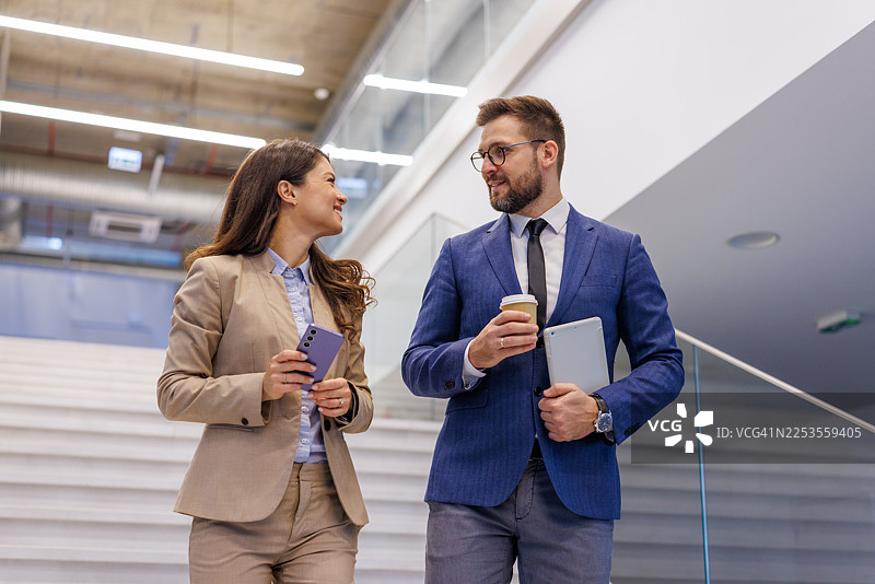 商务同事在现代办公楼下楼图片素材