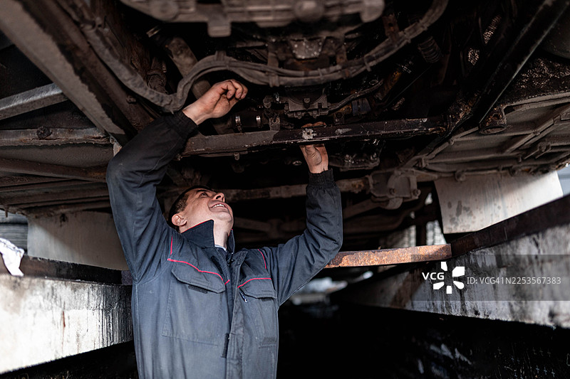 专业技师在车辆下方检修巴士图片素材