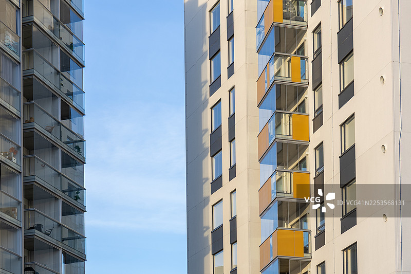 现代公寓楼，带有玻璃阳台，在晴朗的蓝天背景下，低角度视角，芬兰图片素材
