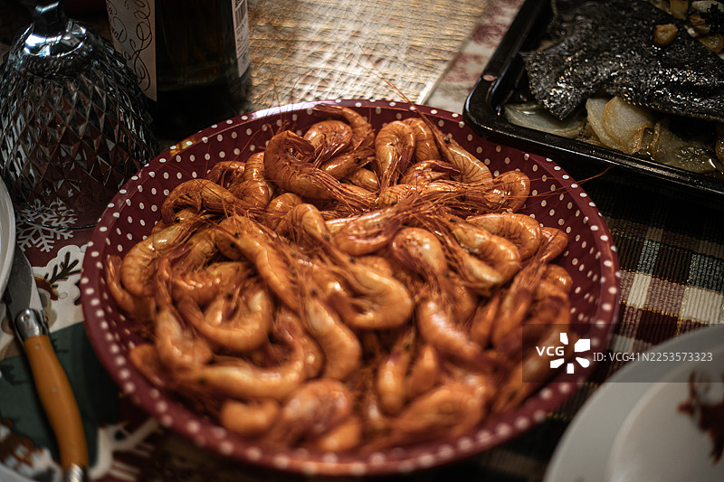 红色的熟虾是焦点，盛放在红白波点图案的餐盘中。图片素材