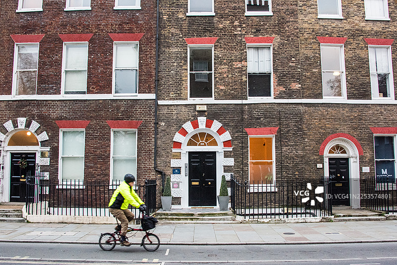 骑行者经过乔治亚风格的联排别墅图片素材