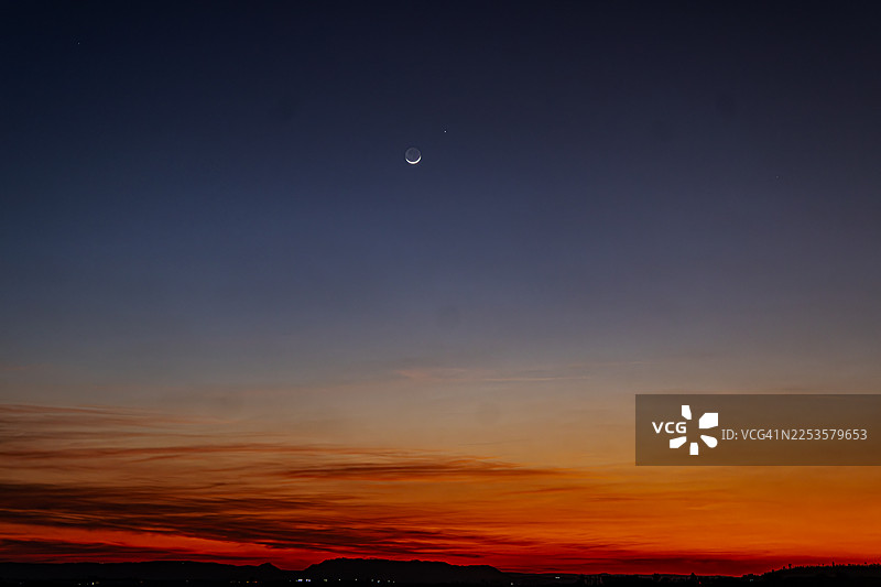 日落时分，月牙形月亮映衬下的剪影风景图片素材