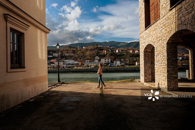 女子在河边探索古城图片素材