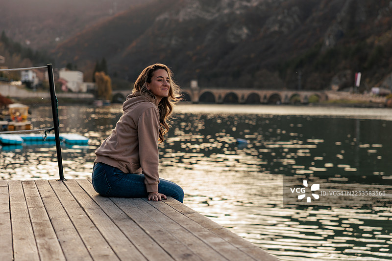 一位女子悠闲地坐在河边图片素材