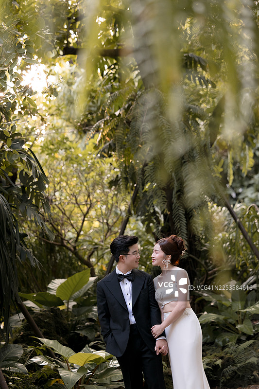 一对快乐的年轻亚洲夫妇在他们结婚的日子，照片为局部裁剪图片素材