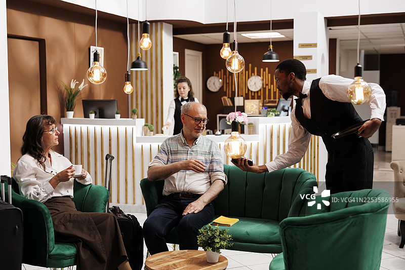 酒店员工在现代典雅的大堂协助客人，在客人入住期间提供卓越的客户服务图片素材