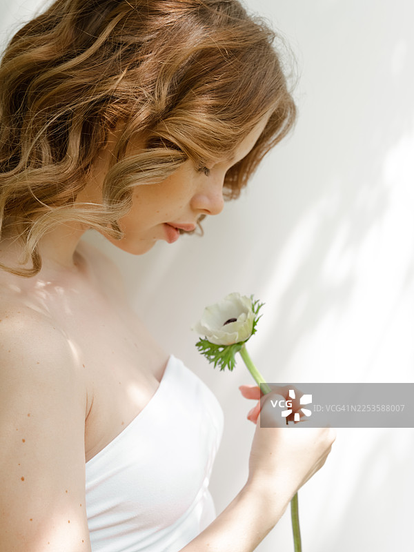 阳光下，皮肤洁净水润的女性的特写肖像图片素材