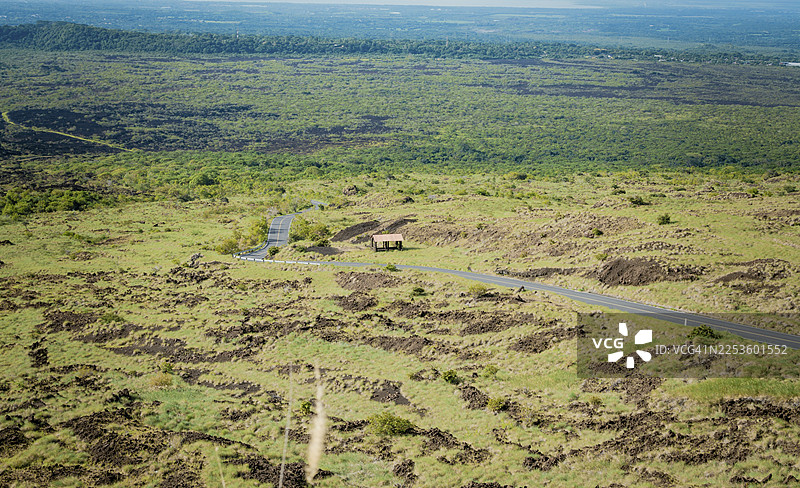 被植被环绕的乡村道路风光。绿意盎然的自然之地的柏油路景观，乡村地点的柏油路空中视角图片素材