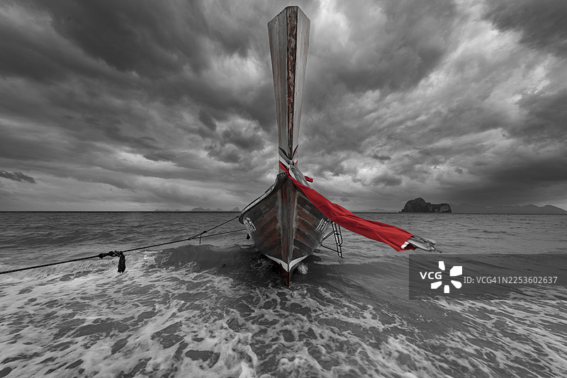 泰国南部，沙敦府，安达曼海，兰岛，沙滩上的长尾船，背景是乌云密布的雨云图片素材