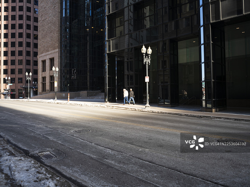 冬季波士顿市中心街道上行走的两个人图片素材