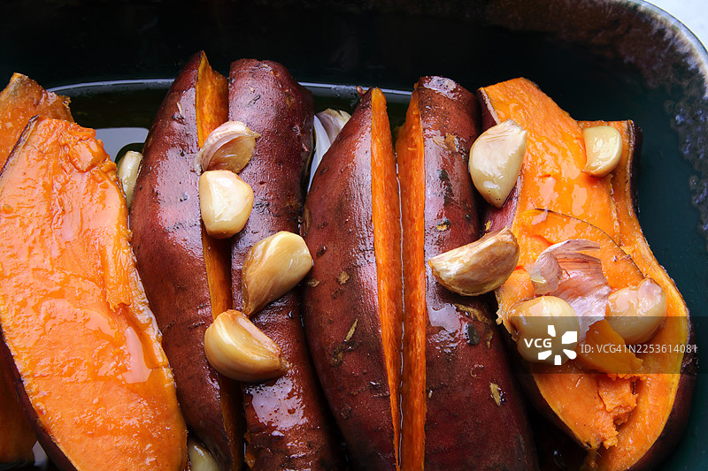 烤箱烤盘中烤红薯和大蒜图片素材