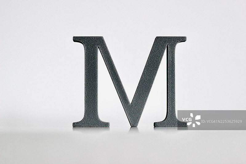 3D打印的字母M，具有金属质感，孤立在白色背景上图片素材