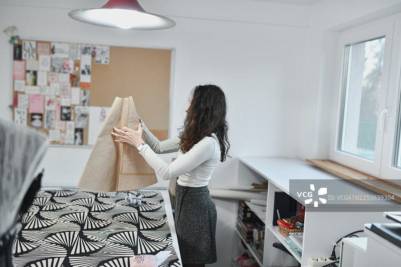 时尚企业主在专业工作室检查布料样品和纺织卷图片素材