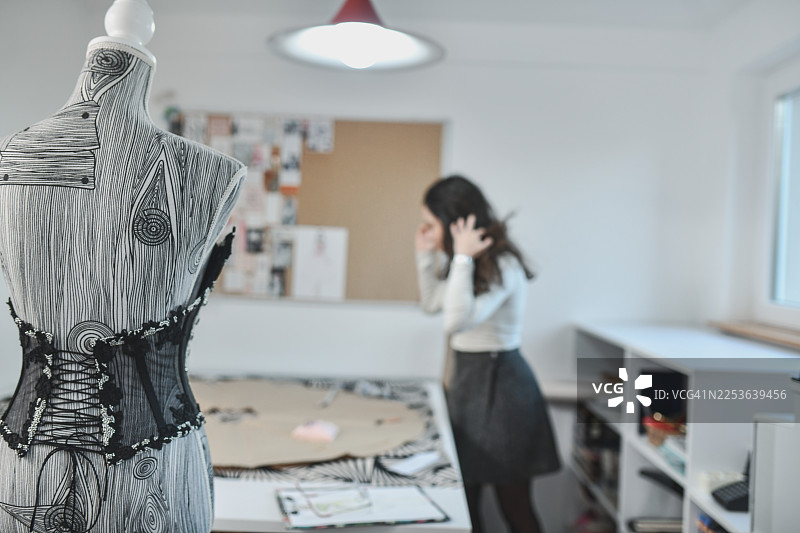 店主在工作室挑选服装生产材料图片素材