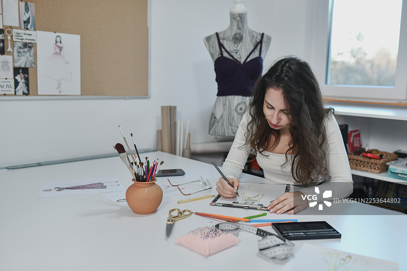 裁缝正在为特殊场合的礼服进行策略规划和材料整理图片素材