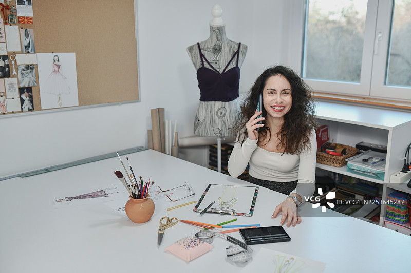 裁缝在定制服装的同时接听多个电话图片素材