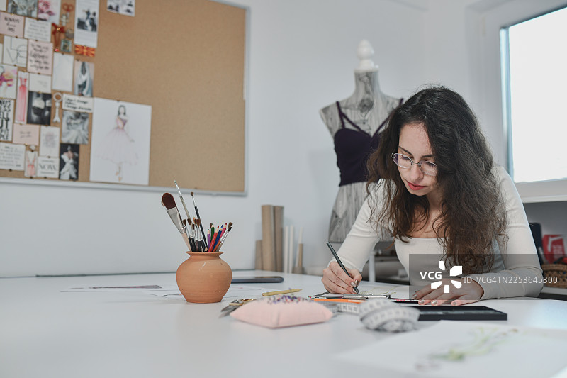 时装设计师为定制服装绘制时尚创意图片素材