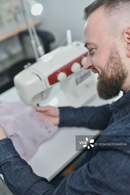 裁缝专注于使用鲜艳的花卉面料制作手工服装图片素材