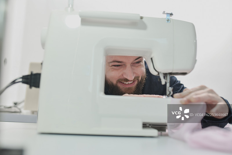 时装设计师使用缝纫机，结合面料和专注，制作定制服装图片素材