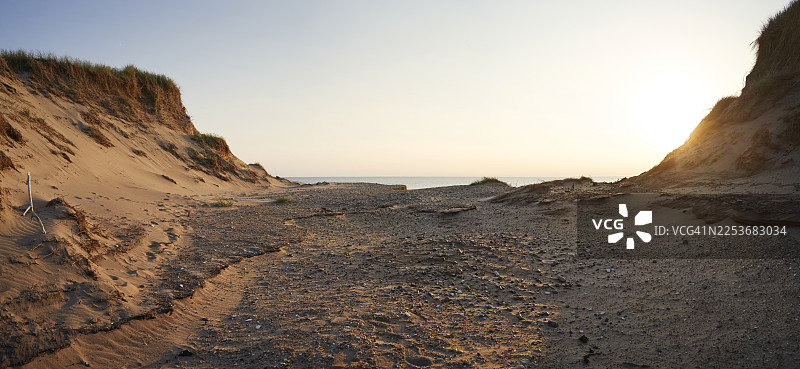 日落时分，平坦的岩石高原与沙丘相邻图片素材