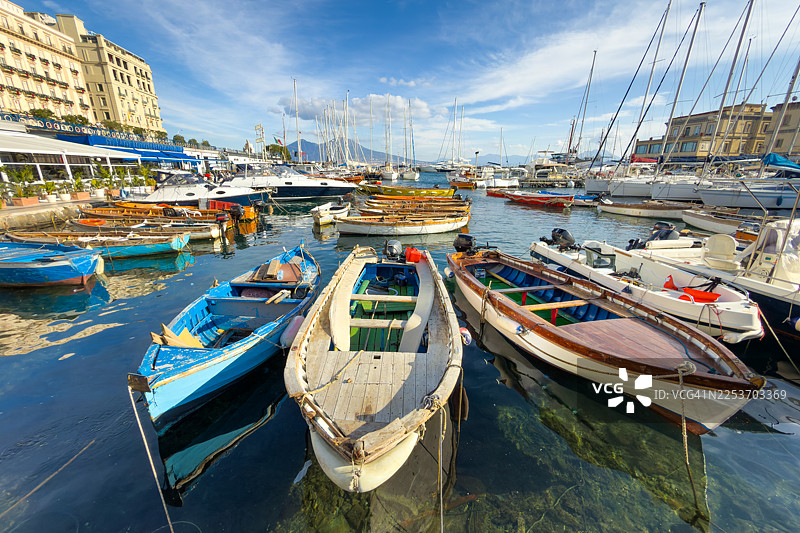 停泊在纳波利港的船只，背景是城市建筑和维苏威火山图片素材