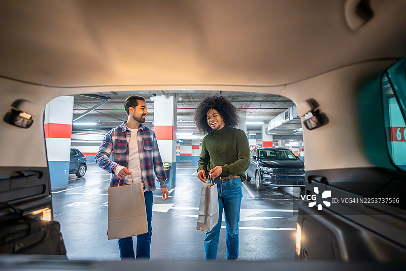 两个朋友将购物袋装进汽车后备箱图片素材