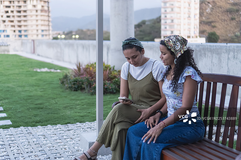 妇女坐在可持续城市花园的长椅上图片素材