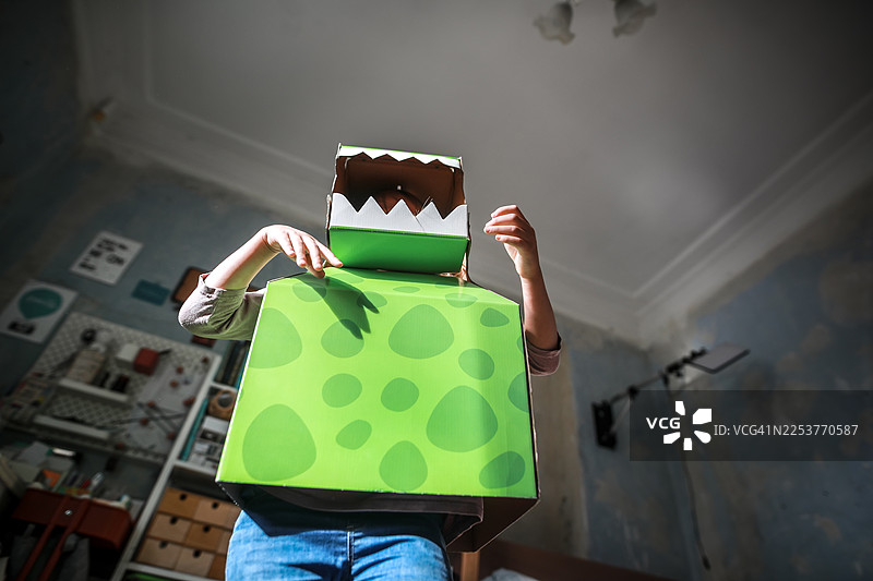 六岁女孩扮演愤怒的恐龙，在阳光下玩耍图片素材