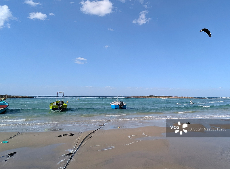 海岸线上的渔船和风筝冲浪活动图片素材