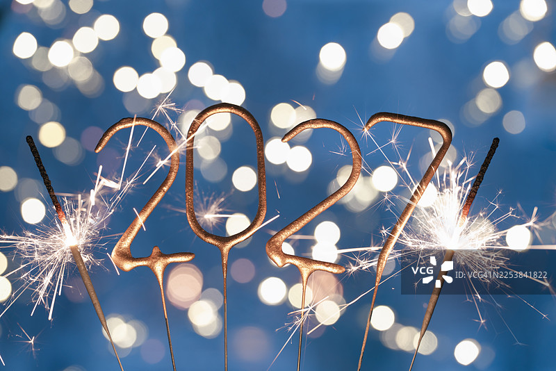 2027年到来之际，在节日聚会上，烟花点亮夜空，呈现出多彩的景象和欢乐的庆祝活动。图片素材