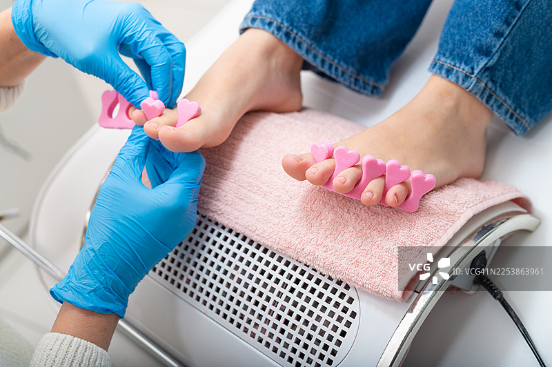 年轻女子在现代美容水疗中心接受足部护理图片素材