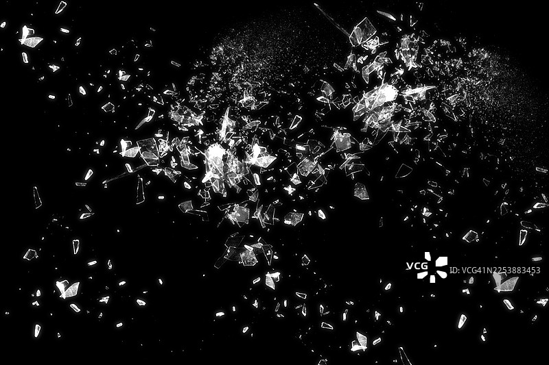 黑色背景上的碎玻璃，细节展示了破碎玻璃的抽象纹理。该图像非常适合用作背景、纹理或抽象艺术项目。图片素材