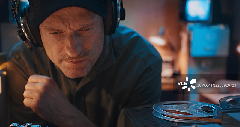 佩戴耳机收听无线电信号的无线电操作员或记者。特写。业余无线电台图片素材