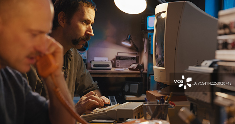 安全房间内的无线电通信设备。两名操作员正在整理软盘数据并接听固定电话。秘密调查记者图片素材