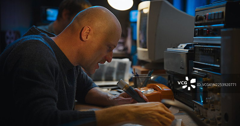 安全房间内的复古无线电通讯设备。两名操作员通过固定电话发送信息。秘密调查记者图片素材