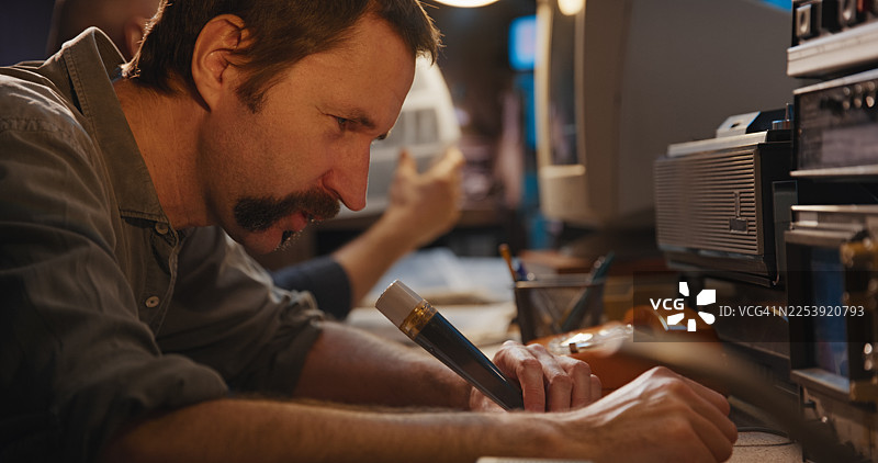 安全房间内的复古无线电通讯设备。两名操作员正通过无线电麦克风发送信息，并记录对话笔录。秘密调查新闻报道图片素材