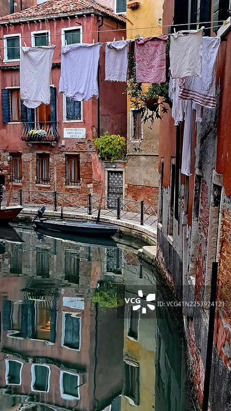 淡季时，威尼斯一条宁静的运河上方晾晒的衣物图片素材